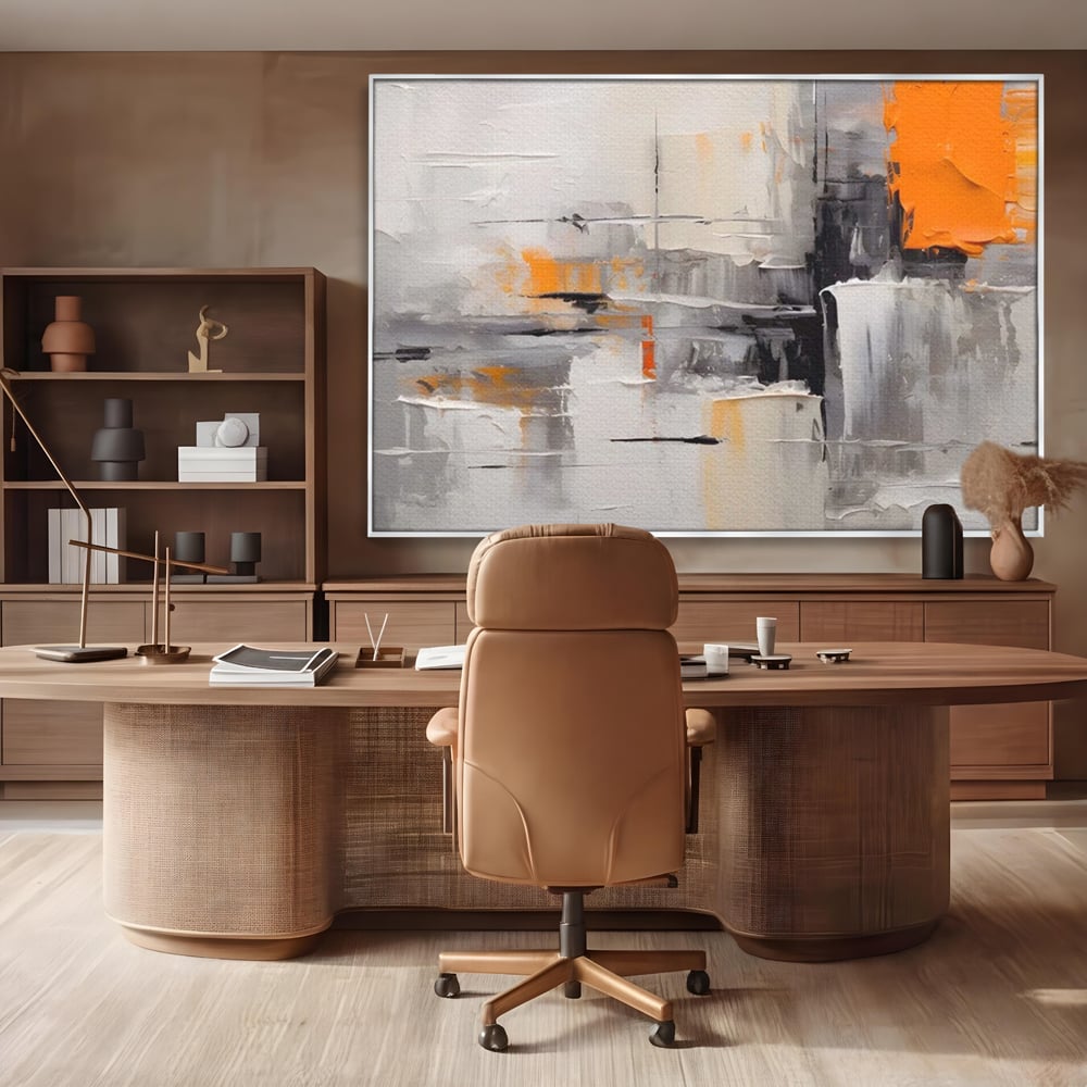 Tablou canvas cu pictura abstracta gri cu pata portocalie, in rama de aluminiu argintiu, pe perete intr-un birou